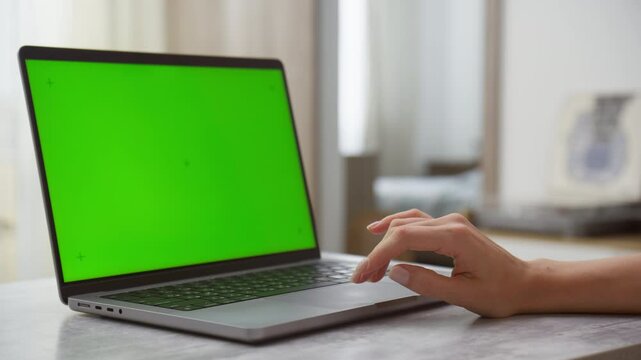 Hand Operating Laptop with Green Screen for Mockup in Bright Room