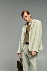 A red-haired teenage boy showcases fashion sensibility in a smart casual ensemble against a grey backdrop.