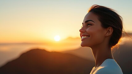 Smiling woman enjoying sunset with mountains in background.