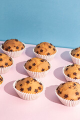 Fresh baked and tasty chocolate chips muffins on color background