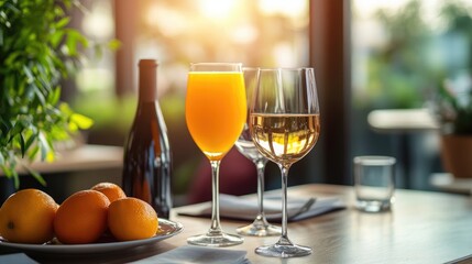 A table set with a glass of orange juice alongside a glass of wine