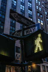 New York City road sign One Way with traffic pedestrian light on the street under sunset light.