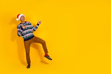 Obraz premium Full size photo of nice young man direct fingers empty space christmas festive time isolated on yellow color background