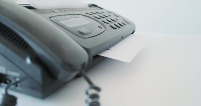 Receiving notice of dismissal by retro fax. Retro office device, sheet of paper with notice of layoffs, inscription fired.