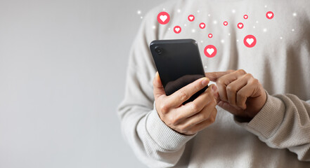 close up young woman hand hold and using smartphone to surf on social media platform and give a heart symbol to trendy or popular image or satisfy content for people and. lifestyle concept