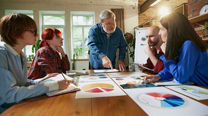 Experienced leader and young professionals collaborate on strategic planning, showcasing teamwork...