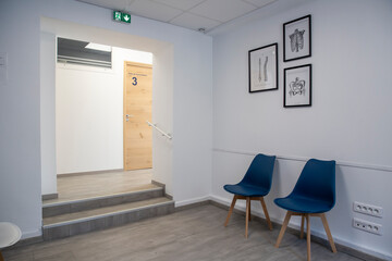 Panorama d'une salle d'accueil et d'attente dans une clinique avec un escaliers, chaises modernes...