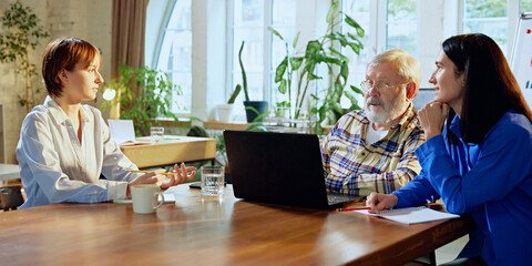 Senior leader shares insights and mentors team, encouraging collaborative approach to business growth. Concept of business, modern office environment, generations together. Ad