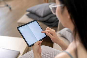 Young woman browsing on  foldable smartphone at home