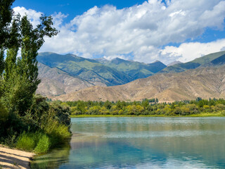 A wooden staircase leading into the clear waters of Issyk-Kul lake, with visible underwater vegetation. A perfect spot for water relaxation and enjoying nature