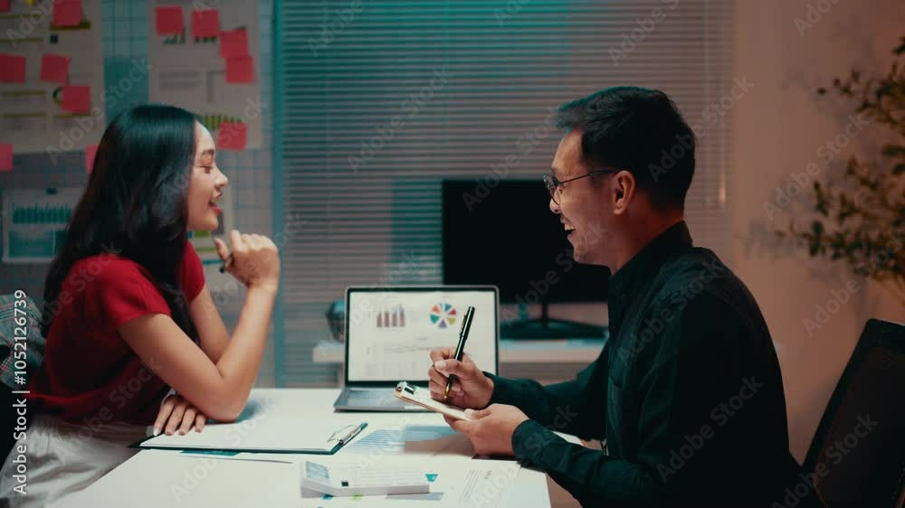 Aufkleber two business colleagues working together in the office at night. they are discussing about a project