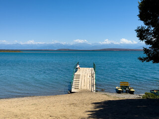 A wooden pier on Issyk-Kul lake with a view of the mountains. A beautiful spot for relaxation and...