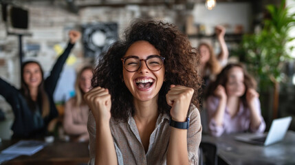 Obraz premium Excited woman celebrating in a collaborative workplace