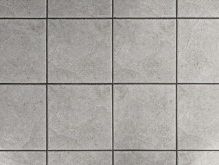 Top view of interior and exterior textured ceramic floor with concrete or gray cement effect. Non-slip lihgt grey square bathroom, terrace, porch tiles with relief texture or background.	