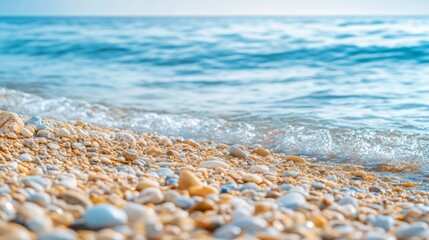 Obraz premium Close-up of a sandy beach with small white rocks and blue water, shallow depth of field.