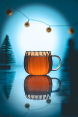 creative winter composition still life with tea in a transparent glass cup, Christmas trees and garland, new year, christmas card, holiday