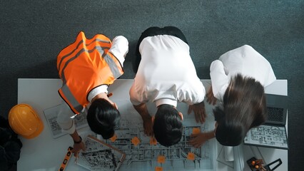 Top down view of project manager and civil engineer hold laptop while explain idea to architect....