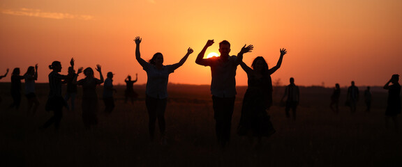 Fototapeta premium Group of friends dancing at sunset outdoors