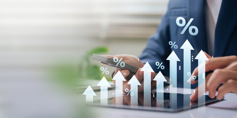 A businessman studies a digital chart with upward arrows and percentage symbols, representing financial growth, progress, and investment returns.