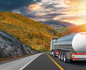 Fuel truck on a picturesque road against the backdrop of an autumn landscape. A tank truck...