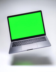 Plain Laptop with green screen floating or flying isolated white background