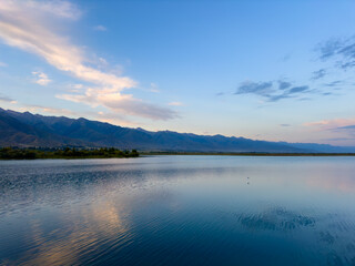 Quiet mountain lake, evening light on the water, Kyrgyzstan. Still water and mountain reflection in the lake