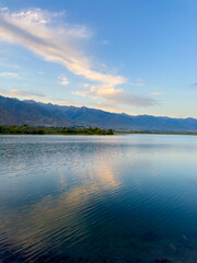 Quiet mountain lake, evening light on the water, Kyrgyzstan. Still water and mountain reflection in the lake