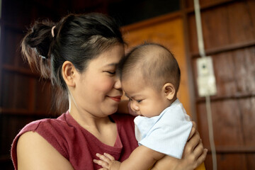 mom and baby are playing on bed happy, asia baby cute 4-5-6 months, activity outdoor of family concept