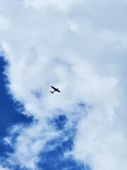 Small aircraft flying in the sky with beautiful puffy clouds