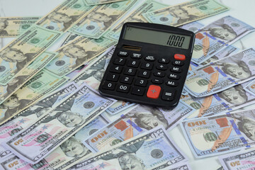 Calculator and a collection of dollar banknotes on the table, financial management concept