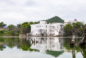 Obraz premium Serene Lake with isolated house and water Reflections Under Bright Sky at morning
