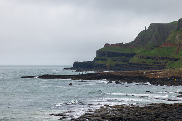 Giant Causeway in Northern Ireland, filled with visitors admiring the famous basalt columns and...