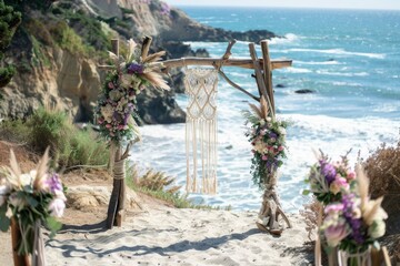 Beachside wedding ceremony setup with floral arrangements and macram&eacute; backdrop at a scenic coastal location during daylight