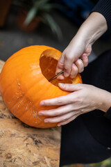 Einen Kürbis zu Halloween mit einem Löffel aushöhlen um ihn dann zu schnitzen