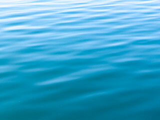 Texture of blue calm water creates a serene and peaceful background. The natural beauty of water reflects the essence of nature, evoking a sense of tranquility reminiscent of the sea.