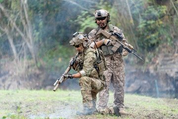 Fototapeta premium Two militaries or soldiers stay in battlefield near the river with one sit down and one stand in the back during outdoor practice.