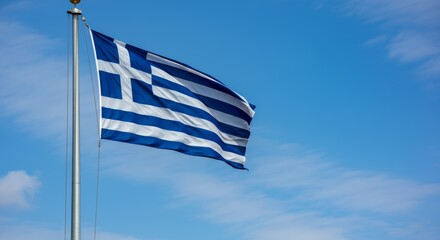 Greek national flag waving on flagpole against clear blue sky.