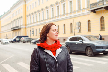 A woman thoughtfully with eyes closed on the street of a historic city. Tourism, walk