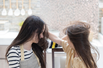Fototapeta premium Two sister grabbing each other hair having a fight