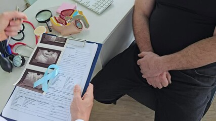 Doctor holding blue ribbon and male reproductive system