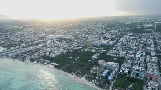 Aerial drone flight video of a paradisiac tourist beach destination in Mexico, Playa del Carmen. 400 meters high view with the sunset on the background