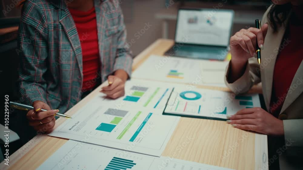 Aufkleber two businesswomen are discussing financial data. they are pointing at charts and graphs with pens, c