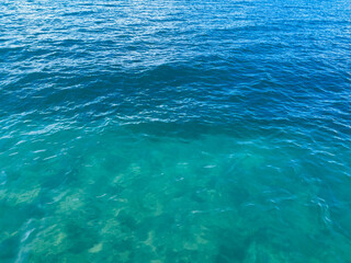 Texture of blue calm water creates a serene and peaceful background. The natural beauty of water reflects the essence of nature, evoking a sense of tranquility reminiscent of the sea.
