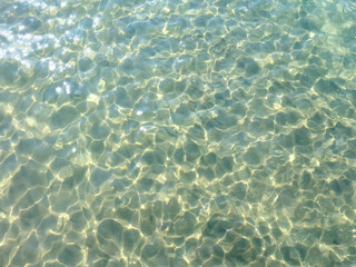 Texture of blue calm water creates a serene and peaceful background. The natural beauty of water reflects the essence of nature, evoking a sense of tranquility reminiscent of the sea.