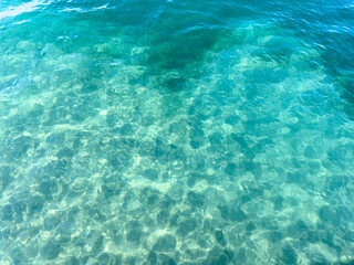 Texture of blue calm water creates a serene and peaceful background. The natural beauty of water reflects the essence of nature, evoking a sense of tranquility reminiscent of the sea.