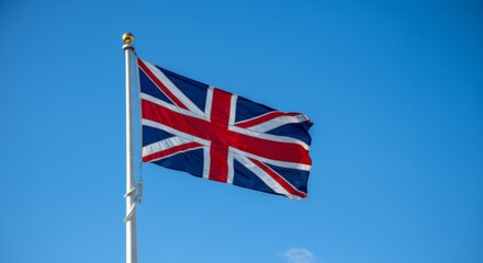 United Kingdom flag waving on flagpole against clear blue sky