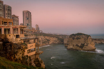 The Beirut waterfront with modern buildings, cafes, promenade and coastal abandoned house at Raouche district, Lebanon.
