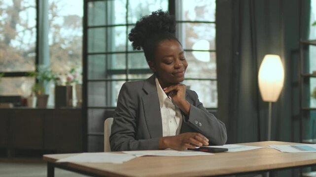 360 degree office. Focused businesswoman sitting at desk with smartphone shaking head. Young woman sitting at workplace with papers on table. Camera moving around. E-commerce concept. Indoors