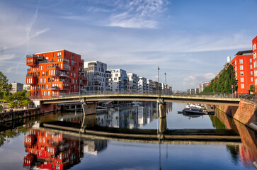 Naklejka premium Frankfurt, Germany - July 29, 2024: Reflections along the Marina Westhafen in Frankfurt in the early morning 