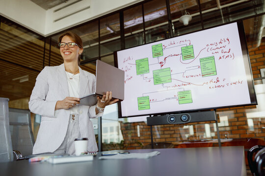 A skilled professional woman delivering a comprehensive business strategy in a modern, contemporary meeting room